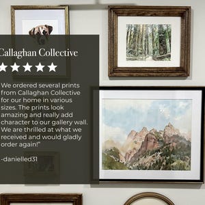 May include: A gallery wall featuring framed art prints. The prints include a dog portrait, a forest scene, and a mountain landscape. The frames are in various styles and colors, including gold and dark wood.