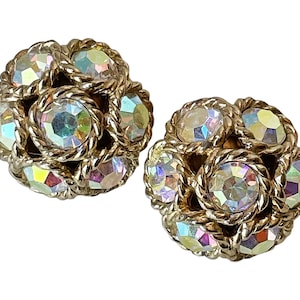 May include: A pair of gold tone clip-on earrings with iridescent rhinestones set in a cluster design.