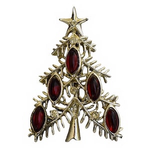 May include: A silver Christmas tree brooch with red glass ornaments and a star on top.