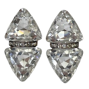 May include: A pair of clear crystal earrings with a silver band of rhinestones around the center of each earring.