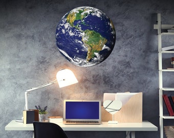 May include: A white desk with a laptop, a lamp, a heart-shaped mirror, and a globe sticker on the wall. The desk has a white chair and a wooden file organizer.