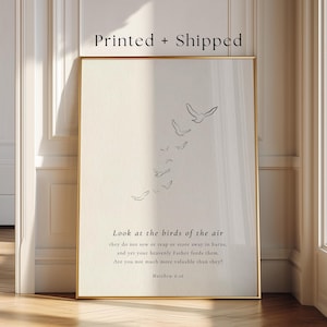 May include: A framed print with a gold border. The artwork features a minimalist line drawing of birds in flight. The text reads "Look at the birds of the air" with a Bible verse from Matthew 6:26.