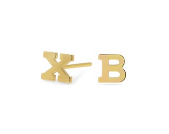 May include: A pair of gold initial stud earrings, one with the letter "X" and the other with the letter "B".
