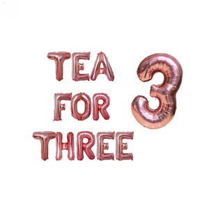 Könnte beinhalten: Roségoldene Folienballons, die "Tea for Three" buchstabieren, mit einem großen Ballon mit der Nummer 3.