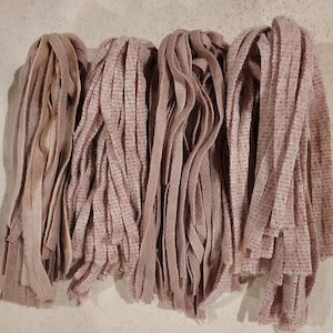 May include: Four bundles of pink and brown wool yarn strips. The yarn is soft and fluffy, and it is perfect for crafting.
