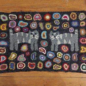 May include: A black and gray hooked rug with two gray cats and a colorful pattern of circles and ovals.
