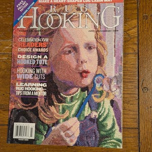 Könnte beinhalten: Ein Magazin mit dem Titel "RUG HOOKING" mit einem farbenfrohen Cover, das ein Porträt einer Frau zeigt. Das Cover enthält Text wie "Readers Choice Awards" und "Hooking with Wide Cuts". Das Magazin ist datiert Juni/Juli/August 2009.