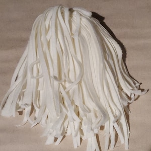 May include: A pile of white wool yarn strips, perfect for crafting projects.