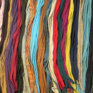 May include: A collection of colorful wool strips, perfect for crafting projects. The strips are various shades of red, blue, green, brown, and yellow.