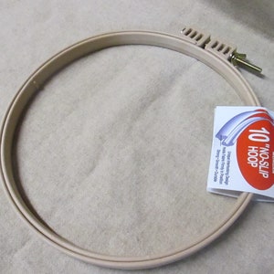 May include: A 10-inch beige plastic embroidery hoop with a no-slip design. The hoop is made by Morgan and is designed for easy fabric handling and positioning. The hoop is sturdy, smooth, and durable.