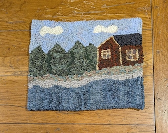 Kit de ganchillo para alfombras rústicas "Cabaña junto al río" con tiras de tela de lana cortadas al número 8.