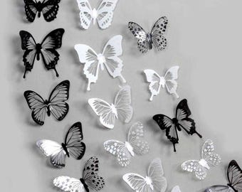 May include: A set of 15 black and white 3D butterfly wall decals. The butterflies are arranged in a random pattern on a gray background.