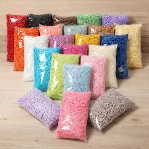Può includere: Una collezione di carta sminuzzata colorata in sacchetti di plastica trasparente. L'assortimento comprende tonalità di rosso, arancione, nero, marrone, verde, viola, rosa, giallo, blu e bianco. Ideale per confezioni regalo o progetti di artigianato.