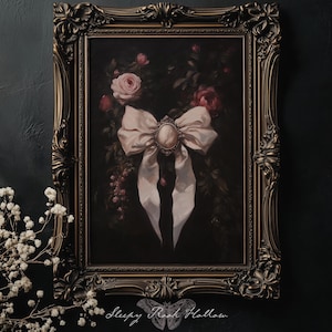 May include: An ornate framed painting featuring a large, light pink bow with a cameo center. The background is a dark, moody floral arrangement with roses. The frame is a dark, antique gold color.