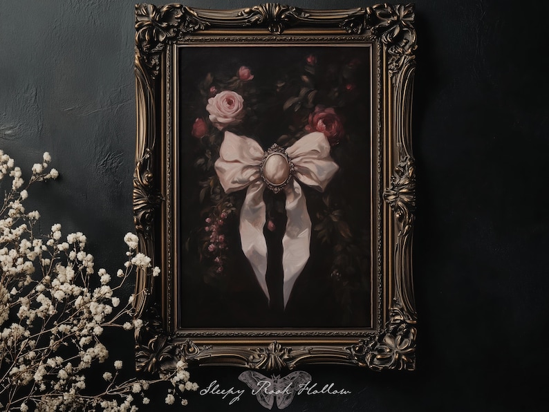 May include: An ornate framed painting featuring a large, light pink bow with a cameo center. The background is a dark, moody floral arrangement with roses. The frame is a dark, antique gold color.