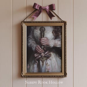 May include: A framed print of a woman in a white dress holding a sword with a gold handle. The frame is gold with a decorative border. The text "SLEEPY ROOK HOLLOW" is printed below the frame.