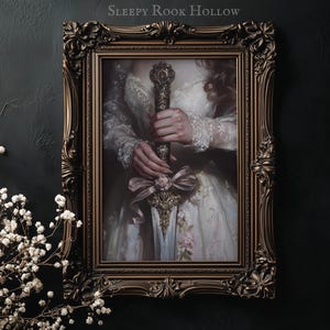 May include: A framed painting of a woman in a white dress holding a sword with a pink ribbon. The sword has a gold handle and a silver blade. The frame is ornate and gold.