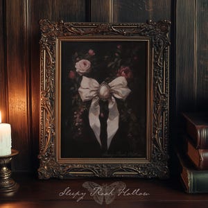 May include: An ornate framed painting featuring a large white bow with a central cameo, surrounded by roses and foliage. The frame is gold-toned, and a lit candle sits to the left. The text "Sleepy Rock Hollow" is at the bottom.