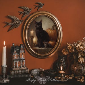 May include: An oval framed painting of a black cat with candles and pumpkins, surrounded by decorative elements. Includes metal swallows, a candle, a haunted house figurine, and dried flowers. The overall theme is Halloween and gothic decor.