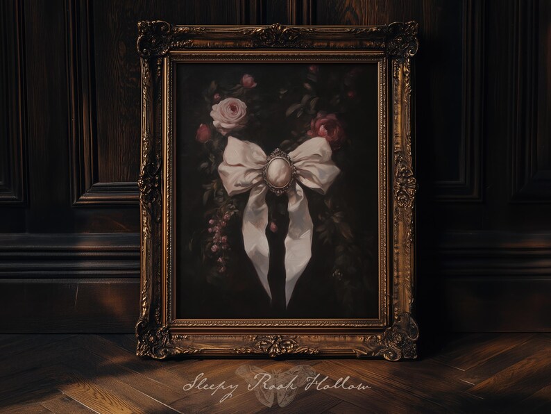 May include: A framed painting featuring a large white bow with a cameo in the center, set against a dark background with roses and foliage. The ornate gold frame adds a vintage touch. The text "Sleepy Rooh Hollow" is at the bottom.
