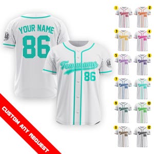 Könnte beinhalten: Weißes Baseballtrikot mit türkisfarbenem Besatz und Schriftzug. Das Trikot trägt den Schriftzug "YOUR NAME" und die Nummer "86" auf der Rückseite. Die Vorderseite des Trikots trägt den Schriftzug "Teamname" und die Nummer "86".