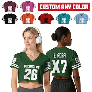 Op de afbeelding: Een verscheidenheid aan korte sportshirts in verschillende kleuren, waaronder bordeauxrood, roze, zwart, oranje, rood, blauwgroen en lichtblauw. Elk shirt heeft het nummer "86" en de tekst "TERM NAME". De tekst "CUSTOM ANY COLOR" staat in een rode banner.
