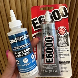 May include: Two tubes of adhesive. One is labelled "liquidFUSION" and the other "E6000". The liquidFUSION tube is 118 ml and the E6000 tube is 59.1 ml. Both are industrial strength and clear, suitable for various materials.