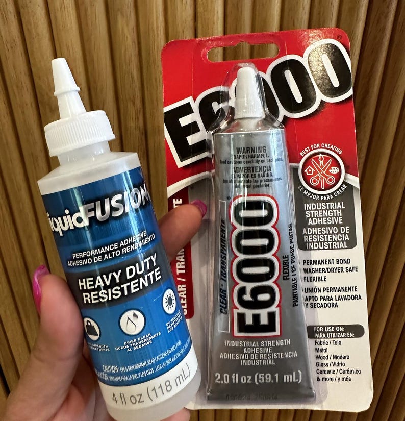 May include: Two tubes of adhesive. One is labelled "liquidFUSION" and the other "E6000". The liquidFUSION tube is 118 ml and the E6000 tube is 59.1 ml. Both are industrial strength and clear, suitable for various materials.
