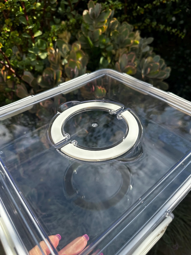 Puede incluir: Contenedor de almacenamiento de pl&aacute;stico transparente con tapa blanca y cierre circular. El contenedor est&aacute; vac&iacute;o.