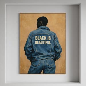 May include: A framed artwork featuring a person in a denim jacket and jeans, viewed from the back. The jacket displays the text "BLACK IS BEAUTIFUL" in white. The background is a warm, textured tan color.