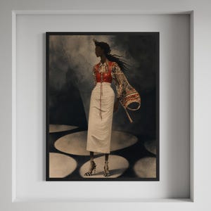 Op de afbeelding: Een ingelijst kunstwerk met een persoon in een rode en patroon top, een lange witte rok en schoenen met patroon. De achtergrond is donker met cirkelvormige lichtpatronen. Het kunstwerk is ingelijst.