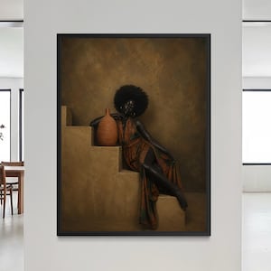 May include: A framed artwork depicts a person in a flowing, rust-colored dress, seated on a set of steps. The person has dark skin and a large afro, holding a terracotta-colored vase. The background is a textured, warm-toned wall.