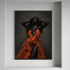 May include: A framed wall art print featuring a person with dark skin and long curly hair wearing a vibrant orange, multi-layered ruffled dress with a deep V-neckline and a high leg slit. The figure is posed with arms raised against a dark background.