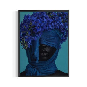 May include: A framed art print featuring a person with dark skin, their eyes covered by a blue fabric. A crown of vibrant blue flowers adorns the head. The background is a solid teal color, creating a striking contrast.