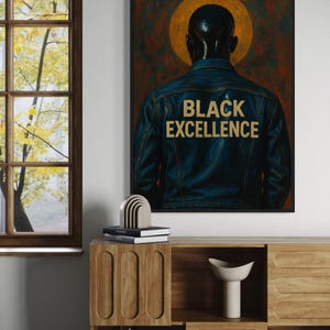 Puede incluir: Obra de arte enmarcada que presenta a una persona con una chaqueta vaquera azul con las palabras "BLACK EXCELLENCE" en letras doradas. La obra tiene un fondo oscuro con un halo dorado. La imagen se muestra en una habitaci&oacute;n con muebles de madera.
