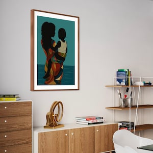 May include: A framed art print featuring a silhouette of a person holding a child. The figures are black against a teal background with a depiction of water. The person's clothing is patterned with orange, yellow, and blue. The frame is brown.