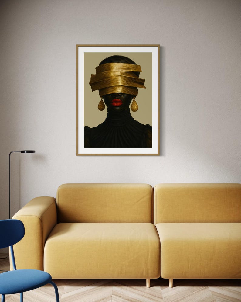 May include: Framed art print featuring a portrait of a person with a gold head wrap and gold teardrop earrings. The person has red lipstick and is wearing a black turtleneck. The artwork is displayed on a neutral wall above a yellow sofa.