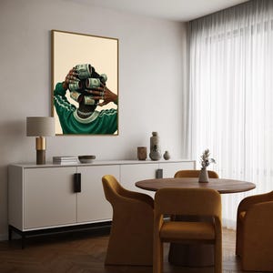 May include: A framed art print depicts a person with dollar bills rolled into curlers. The person wears a green and white track suit and a silver chain. The artwork hangs in a dining room with a white sideboard, round table, and mustard-colored chairs.
