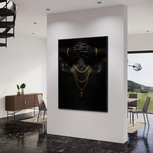 May include: A framed art print featuring a black and white image of a person's back, adorned with gold jewelry. The person's hands are behind their head, and gold chains and a pendant are visible. The artwork is displayed in a modern interior setting.