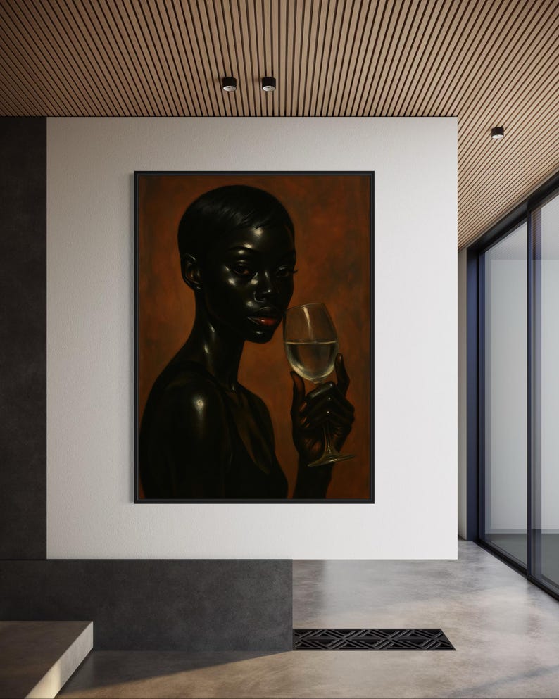 May include: A framed art print featuring a dark-skinned person holding a glass of white wine. The person has short hair and red lipstick. The background is a gradient of brown and orange tones. The artwork is displayed in a modern interior setting.