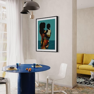 May include: A framed art print depicting a mother and child in silhouette, set against a teal background with a suggestion of water. The mother wears a colorful patterned garment. The scene is in a dining room with a blue table and white chairs.