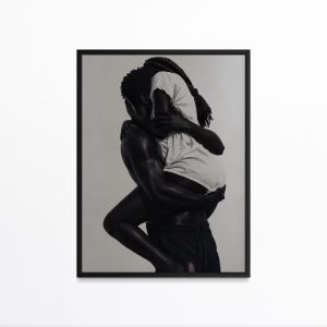 May include: Black and white framed art print depicting two figures embracing. One figure, wearing a white shirt, is held by another figure. The artwork is a monochromatic representation of intimacy and connection.