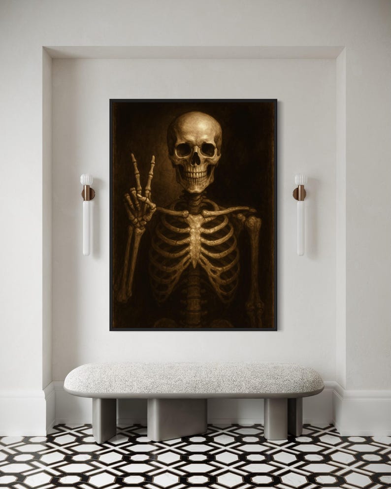 Puede incluir: Una obra de arte enmarcada en tonos sepia que representa un esqueleto humano haciendo el signo de la paz. El esqueleto est&aacute; centrado, con un fondo oscuro. La obra se exhibe sobre un banco gris en un pasillo blanco con apliques decorativos.