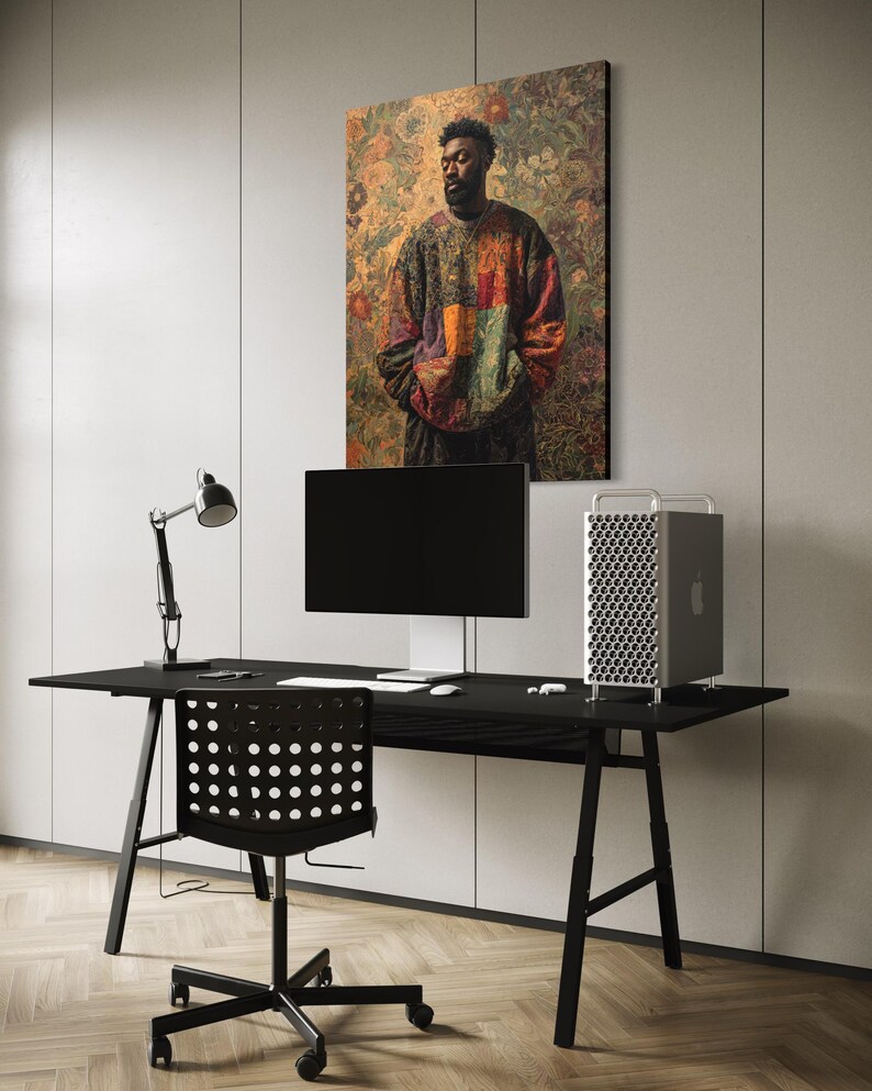 K&ouml;nnte beinhalten: Ein modernes B&uuml;ro mit einem schwarzen Schreibtisch, Stuhl und Monitor. Ein gro&szlig;es gerahmtes Kunstwerk mit einem Portr&auml;t einer Person in einem bunten Pullover h&auml;ngt an der Wand. Ein silberner Computer-Tower und eine schwarze Schreibtischlampe sind ebenfalls zu sehen.