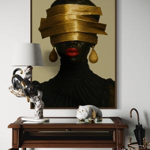 May include: A framed portrait of a person with dark skin, red lips, and gold-colored blindfold and earrings. A black and white panther lamp and a bulldog figurine sit on a dark wood table. An umbrella stand is in the background.