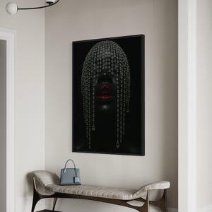 Pode incluir: Uma impress&atilde;o de arte emoldurada com um retrato de uma pessoa com pele escura, adornada com um adorno de cabe&ccedil;a com joias e l&aacute;bios vermelhos. A obra de arte est&aacute; pendurada acima de um banco com uma bolsa azul e t&ecirc;nis.