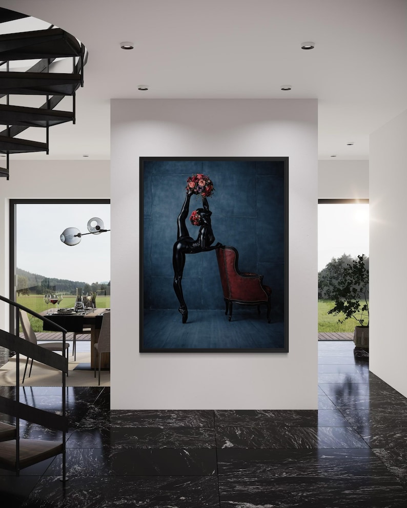 May include: A framed art print showing a black sculpture of a person in a ballet pose, holding a bouquet of red flowers. The sculpture is set against a blue textured backdrop, with a red armchair nearby.
