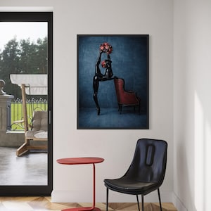 May include: A framed art print showing a black sculpture of a dancer with a bouquet of red flowers, next to a red armchair. A red side table and a black chair are in the foreground. The room has a hardwood floor and a large window.