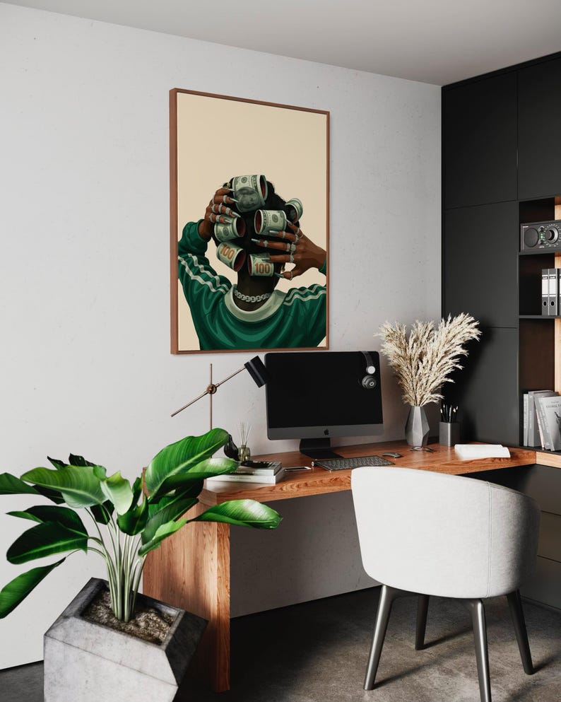 May include: Framed art print featuring a person with dollar bills styled as hair rollers. The person is wearing a green and white track suit. The artwork is displayed in a modern office setting with a wooden desk, computer, and a white chair.
