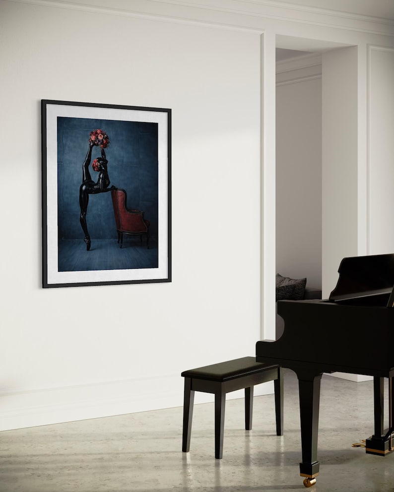 May include: A framed art print showing a black sculpture of a dancer holding a bouquet of red roses. The dancer is leaning against a red armchair. The background is a dark blue.